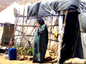 A Syrian refugee steps outside her makeshift housing. Syrian refugees are finding hope in the midst of suffering as they seek answers to their questions about Christ, the cross, and forgiveness.
